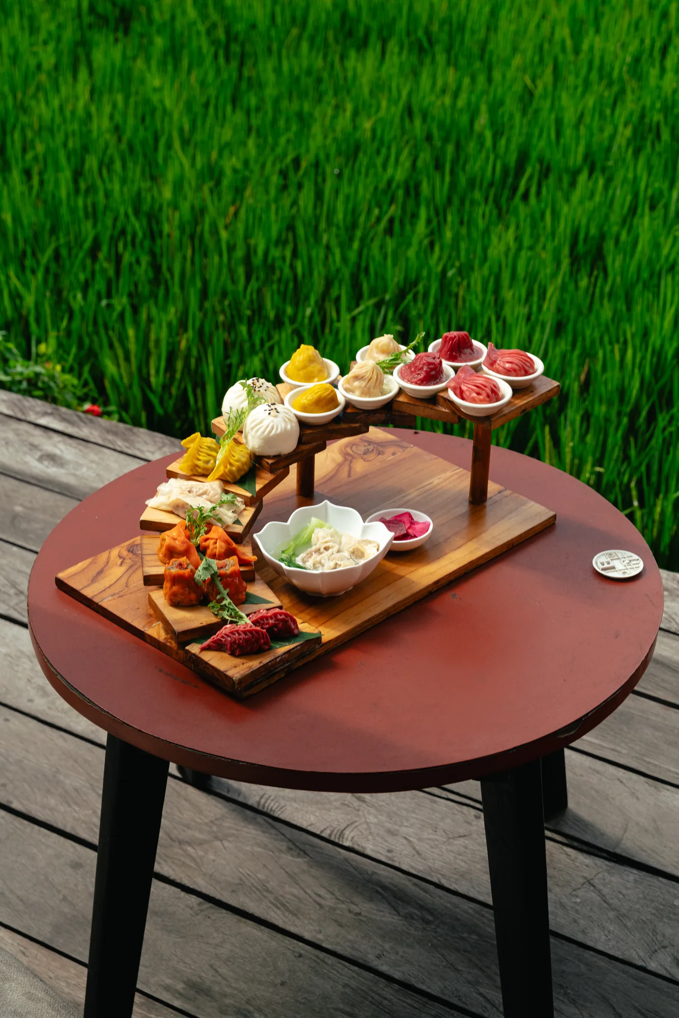 Dumpling flight served on a tiered wooden stand outdoors