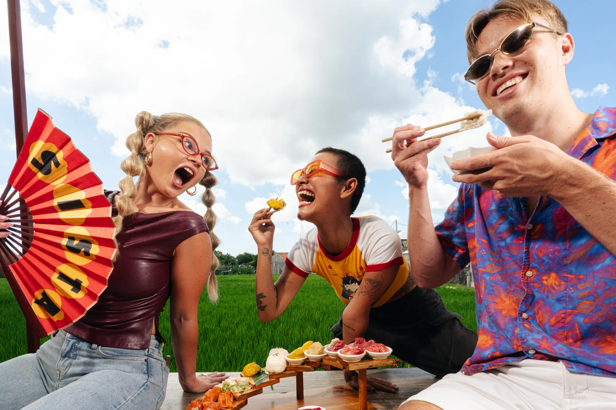 Friends sharing dumplings and laughing with a Sista fan
